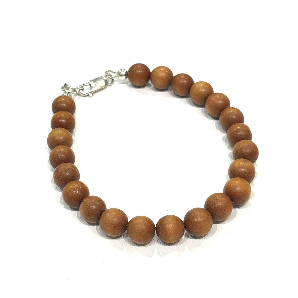 A brown sandalwood beaded bracelet with a sterling silver lobster-claw clasp on a white background, front view.