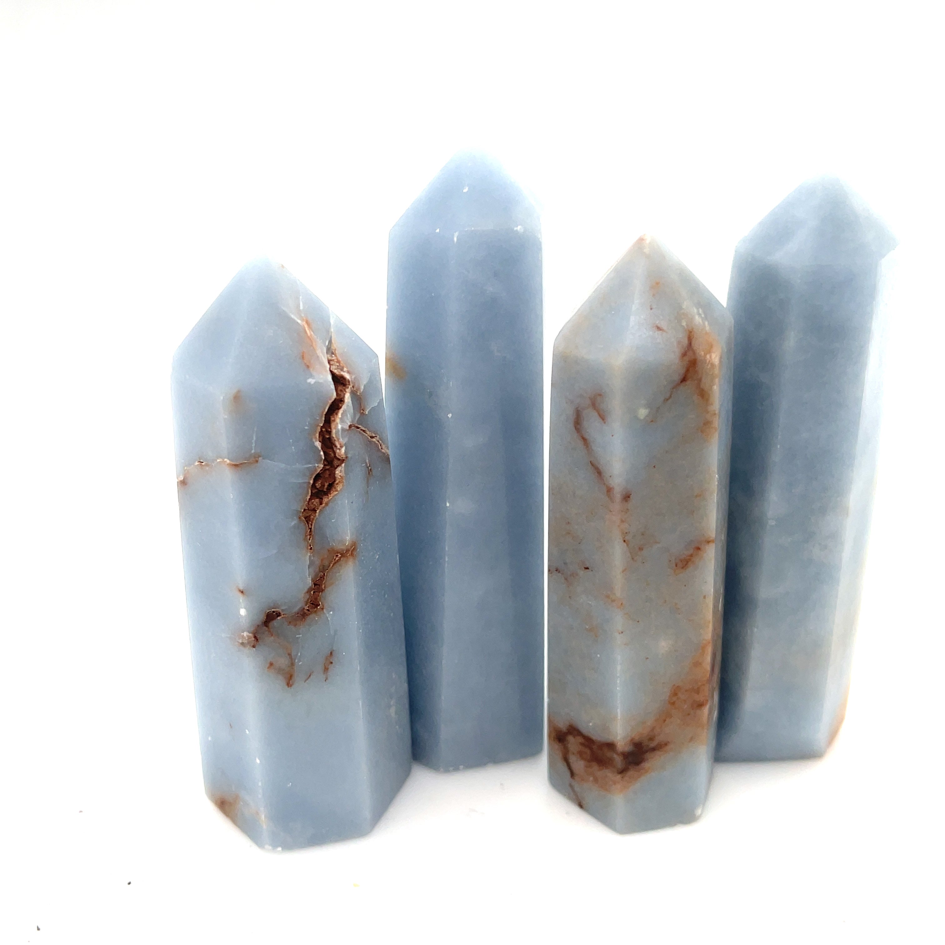 A collection of Angelite gemstone towers displayed together on a white background front, center, close up  overview. 