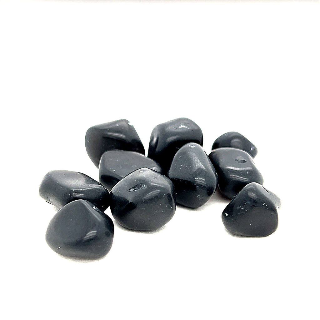 A collection of Apache Tear tumbled gemstones on a white background, front overview. 