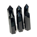 A collection of Black Obsidian Tower gemstones, displayed in a double line on a white background, front close up view. 