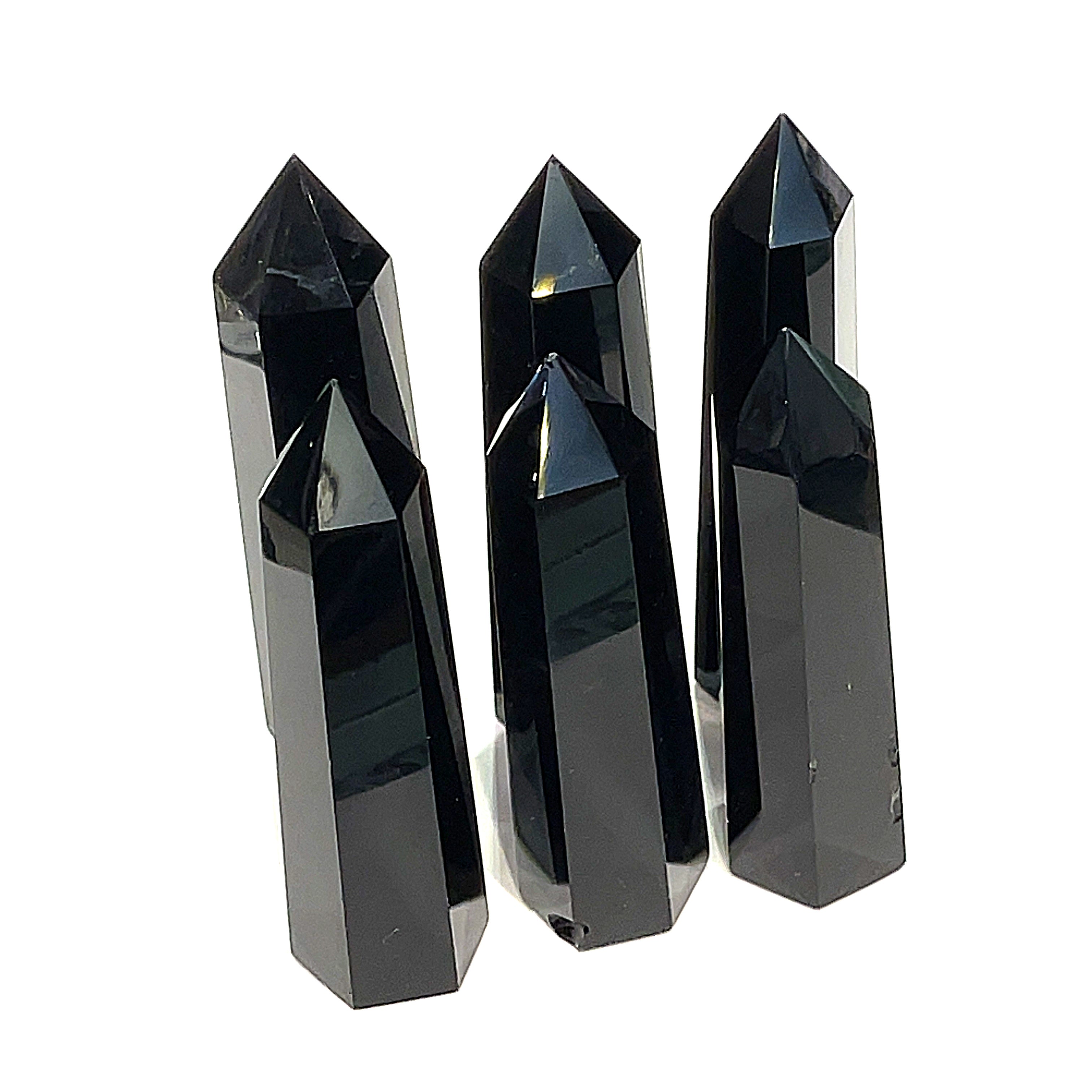 A collection of Black Obsidian Tower gemstones, displayed in a double line on a white background, front close up view. 