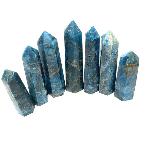 A collection of Blue Apatite Gemstone Towers arranged in a line on a white background, front view.