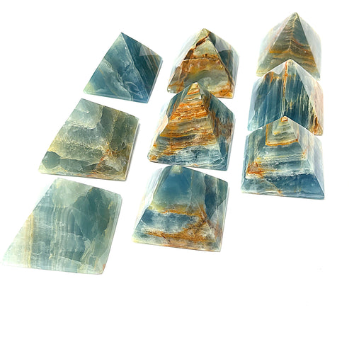 A collection of Blue Onyx gemstone pyramids of various sizes arranged on a white background, front overview.