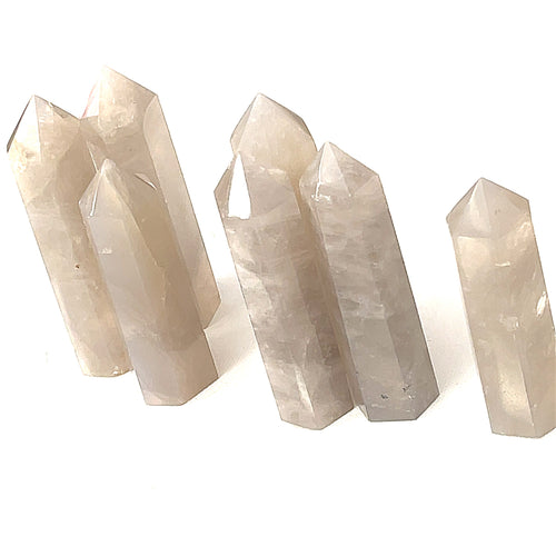 A collection of Blue Rose quartz gemstone towers arranged together against a white background, front overview. 