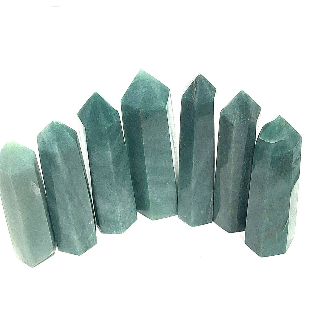 A collection of Green Aventurine Tower Gemstones, pointy and columnar in shape, displayed together in a line  on a white background, front view.