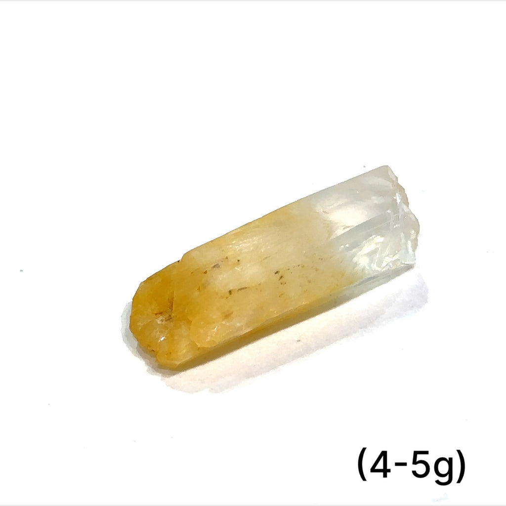 A collection of Halloysite-Included Quartz gemstones, also known as 'Mango Quartz', sizes (4-5g) is displayed on a white surface center overview.