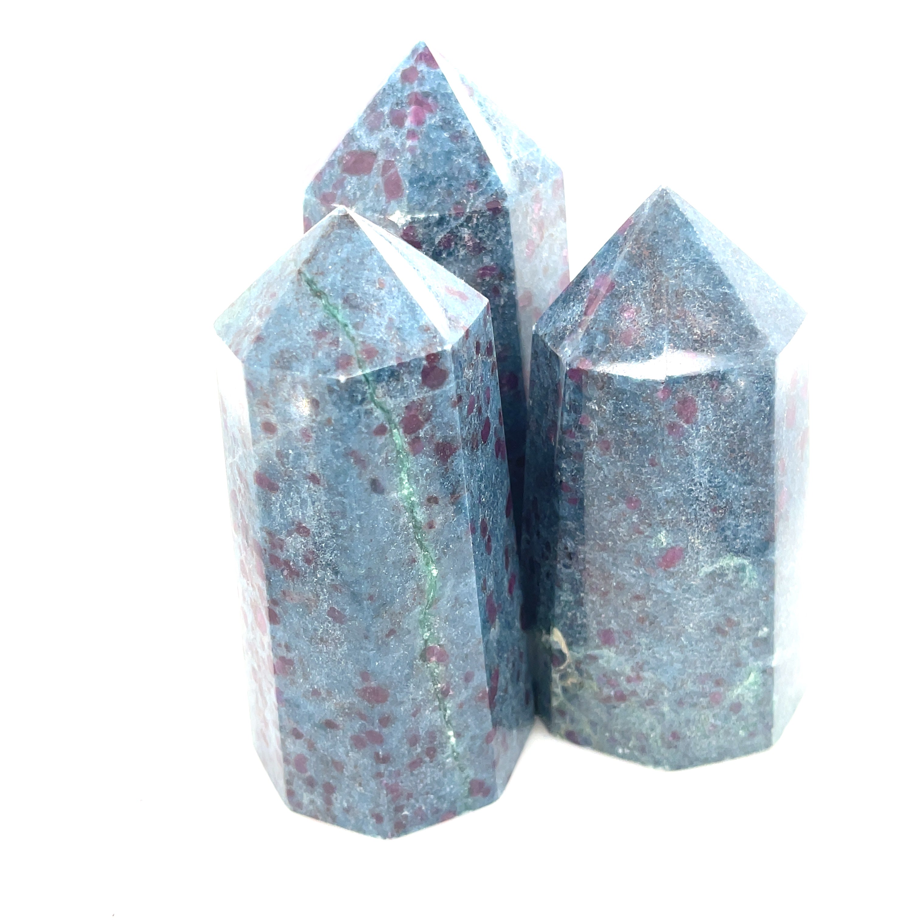 A collection of Ruby Kyanite gemstone towers with a deep blue color and red speckles, displayed on a white background, front close up overview.