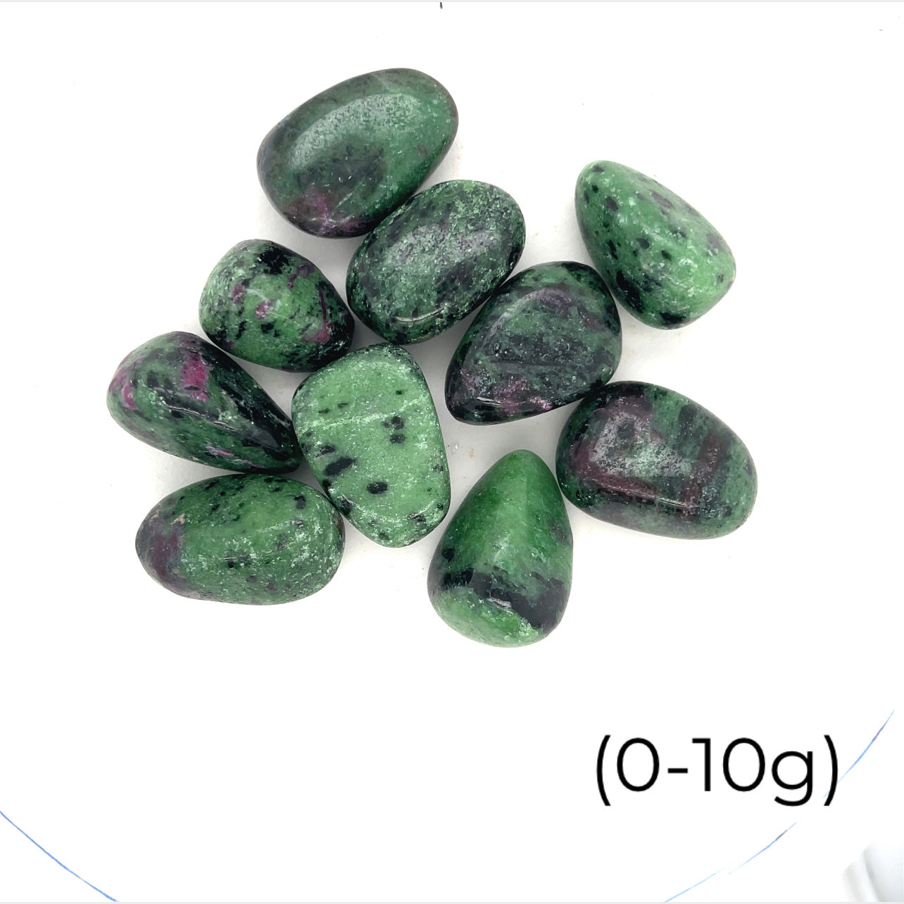 A collection of Ruby in Zoisite tumbled gemstones varying in shades of green with hints of purple, displayed on a white surface. The size of the stones is indicated as 0-10 grams.
