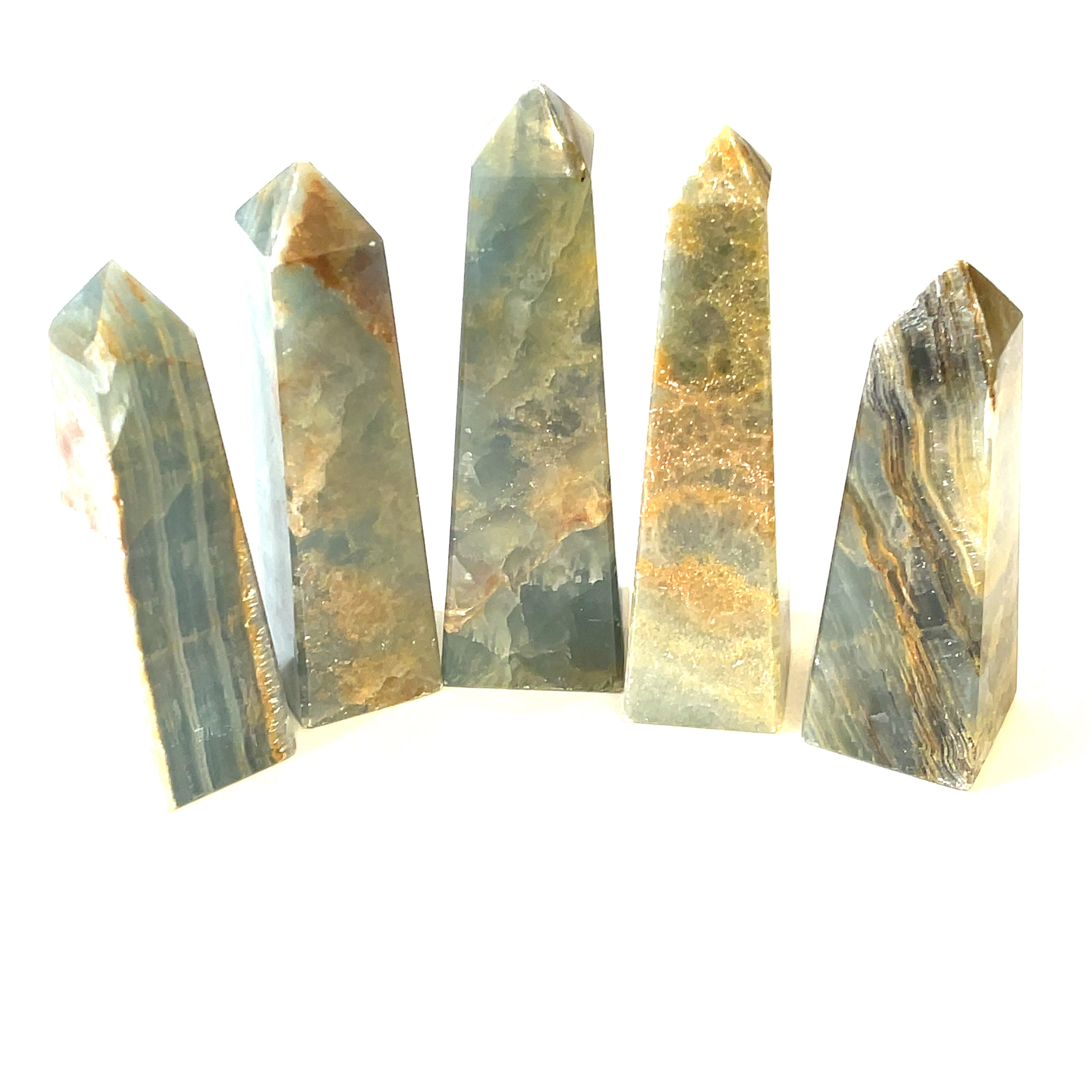 A collection of XXL large sizes of  blue onyx gemstone towers displayed in a group on a white background, front overview.