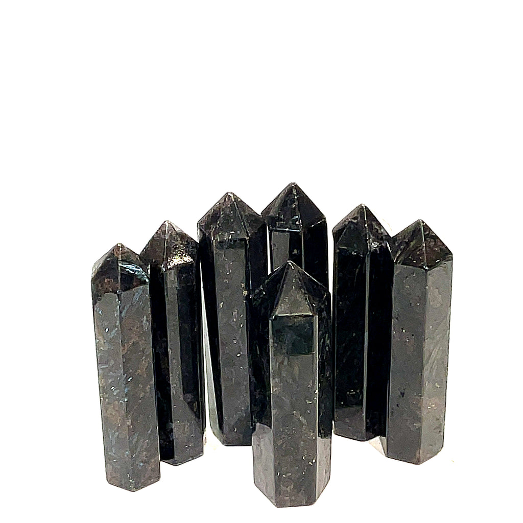 A collection of black Arfvedsonite gemstone towers arranged together on a white background, front, close up view. 