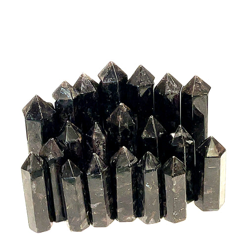 A collection of black Arfvedsonite gemstone towers arranged together on a white background, front view. 