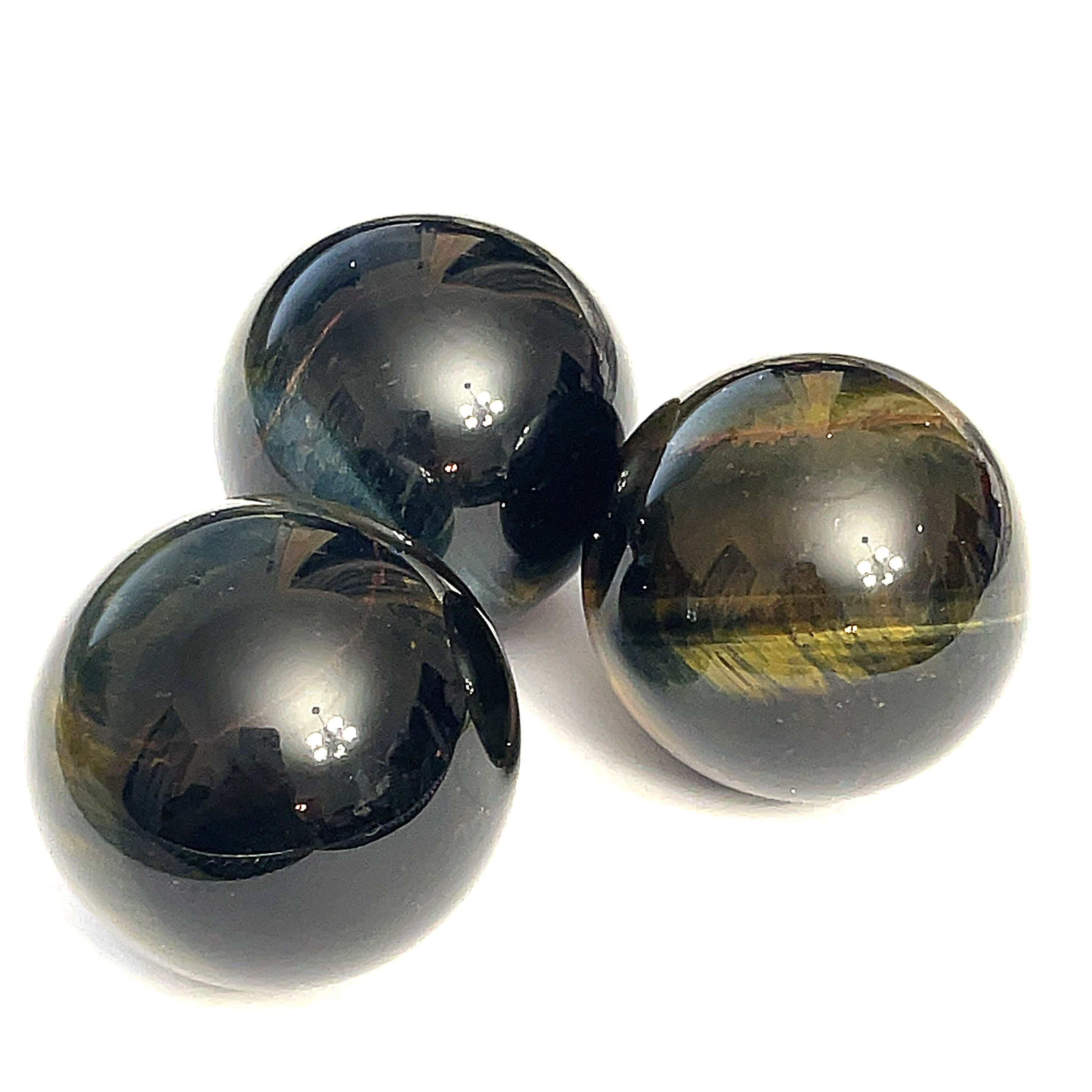 A collection of blue tiger eye gemstone spheres, displayed on a white background in a triangular, front view.