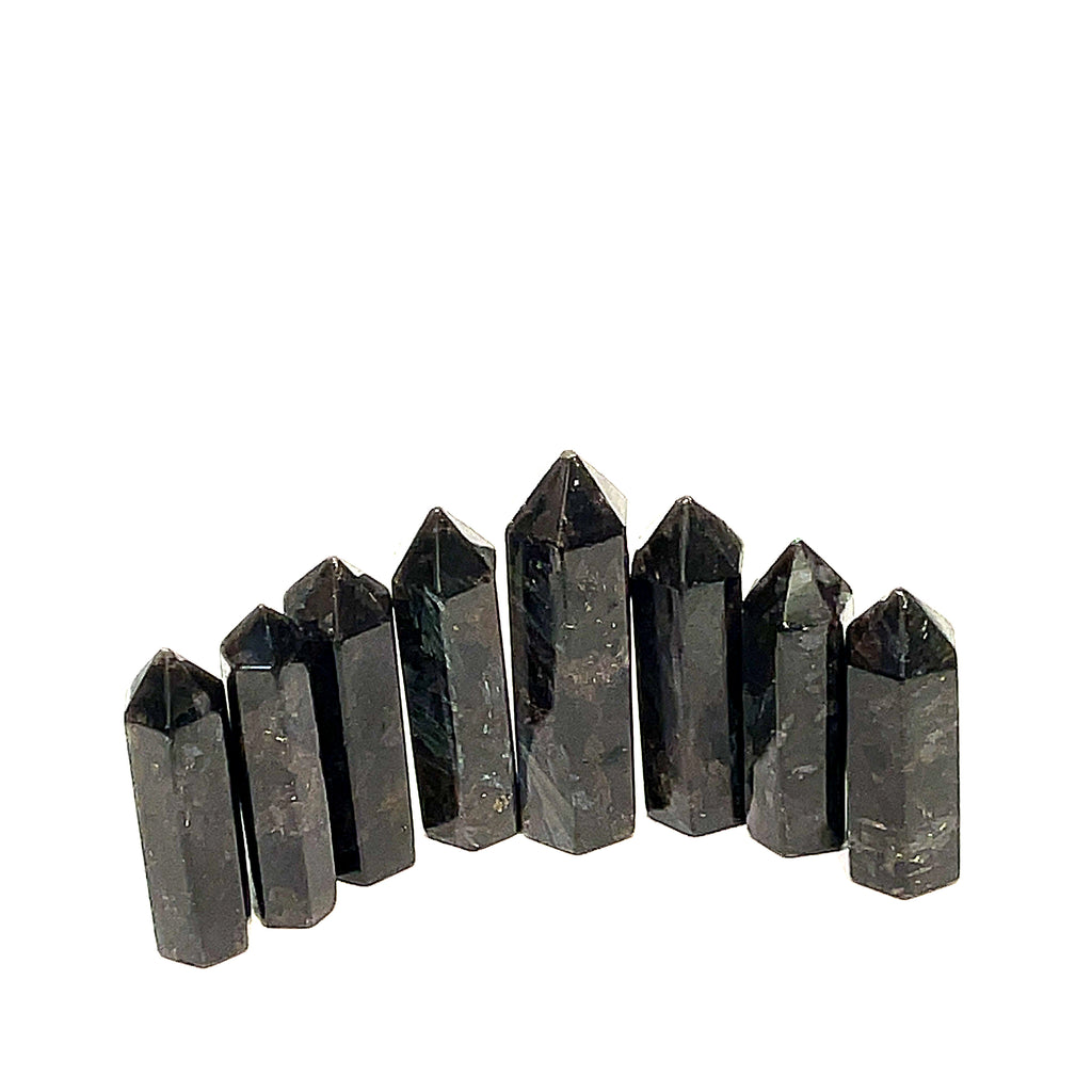 A collection of eight black Arfvedsonite gemstone towers arranged together on a white background, front, close up view. 
