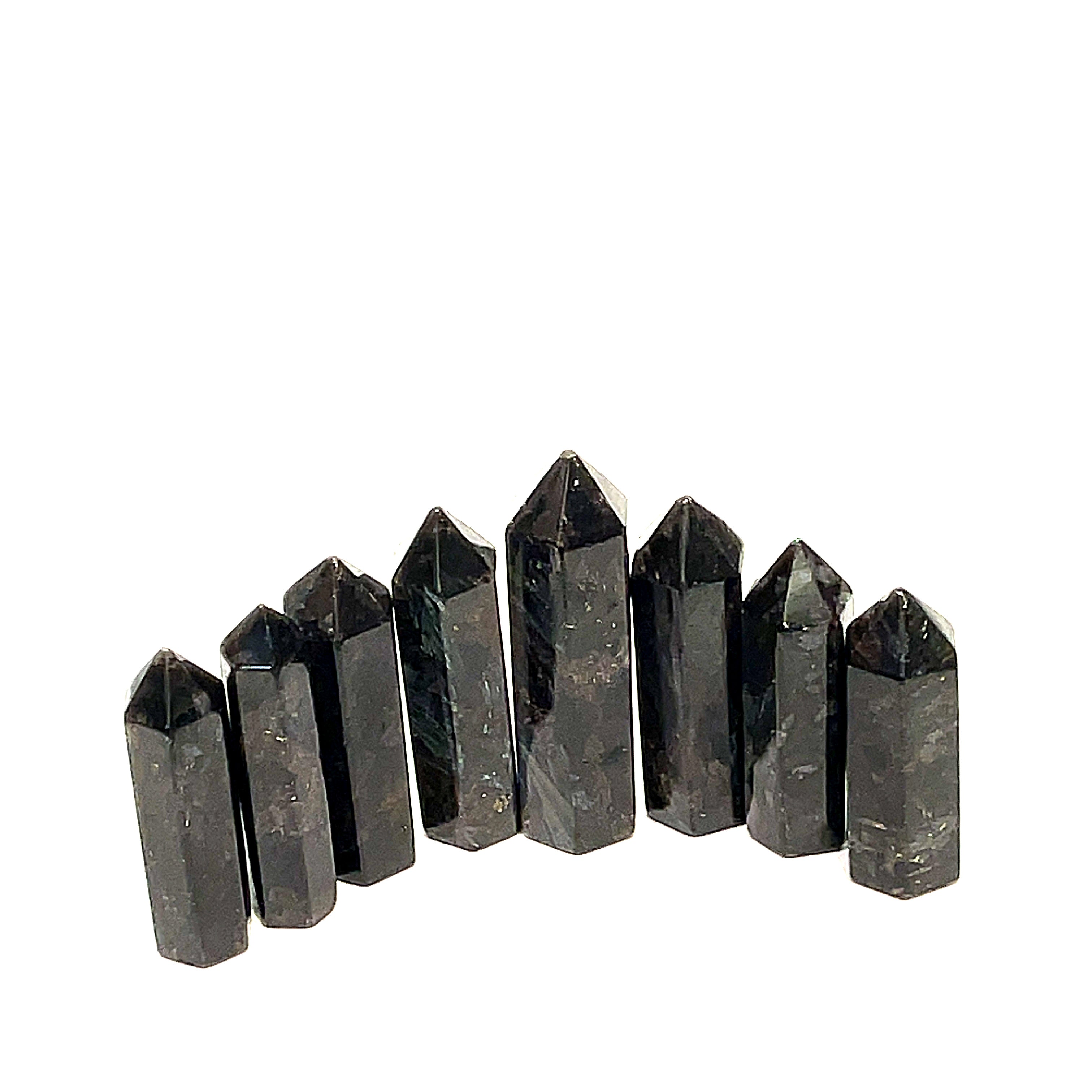 A collection of eight black Arfvedsonite gemstone towers arranged together on a white background, front, close up view. 