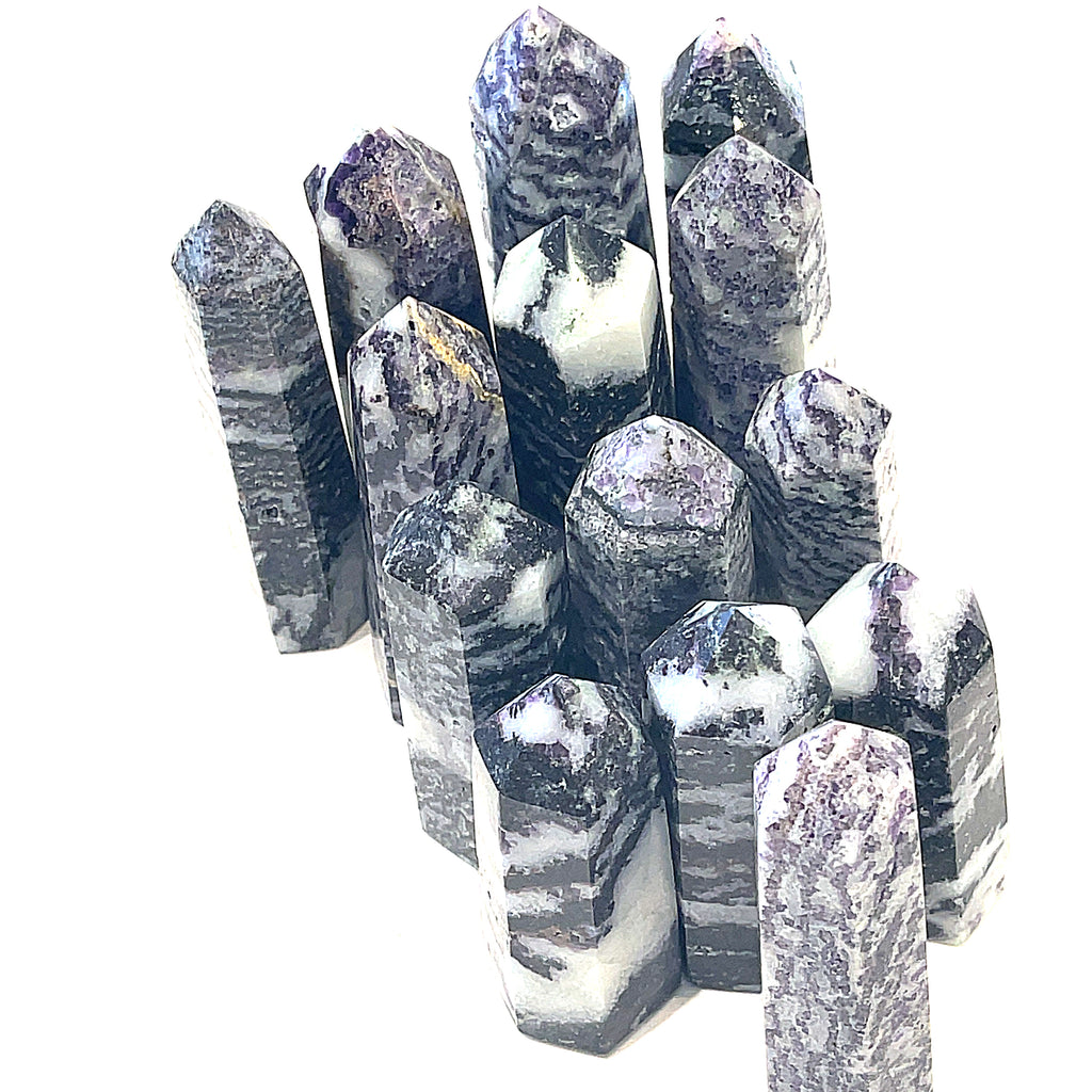 A collection of ethically sourced Tiffany gemstone towers displayed against a white background, with varying shades of purple and white patterns, overview. 