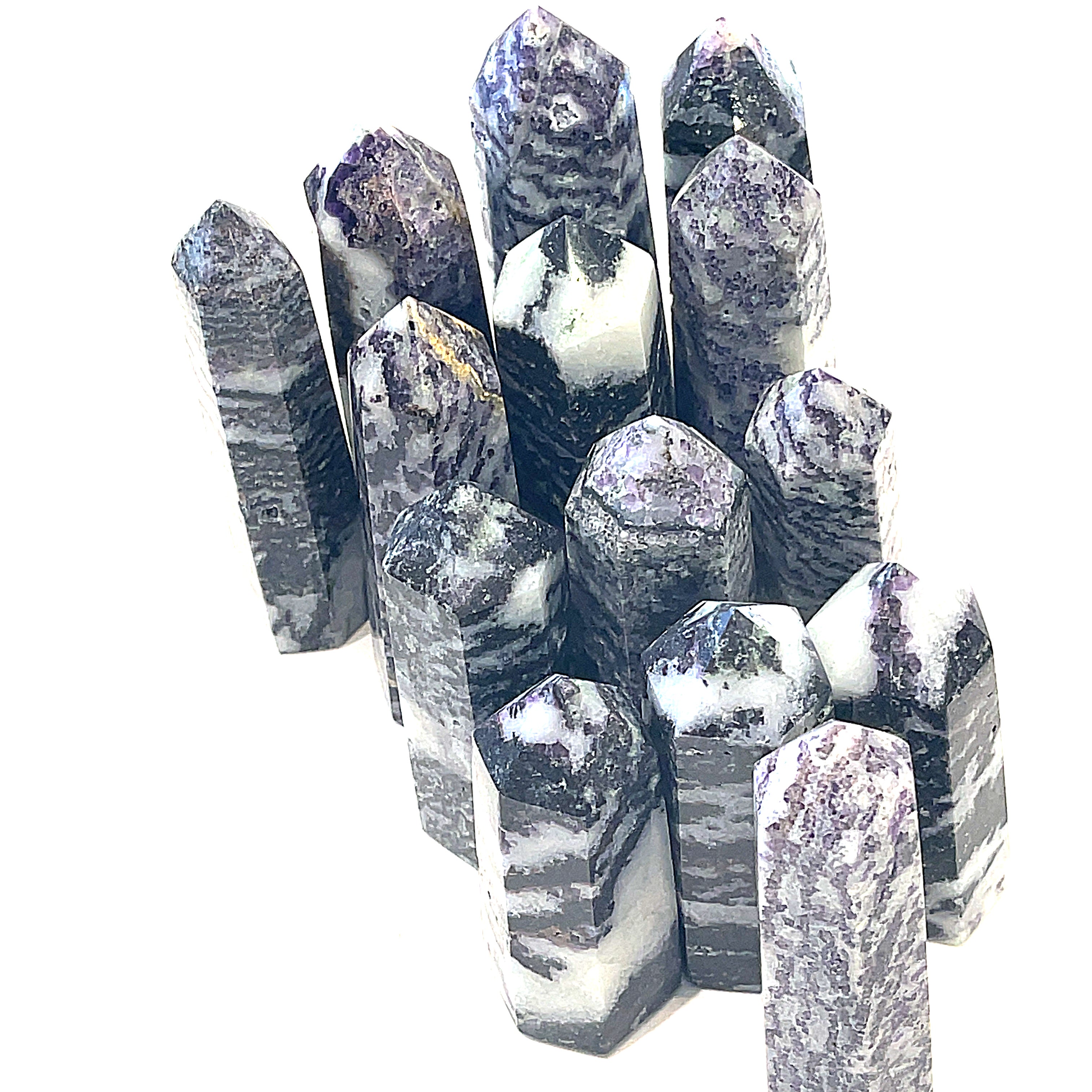 A collection of ethically sourced Tiffany gemstone towers displayed against a white background, with varying shades of purple and white patterns, overview. 