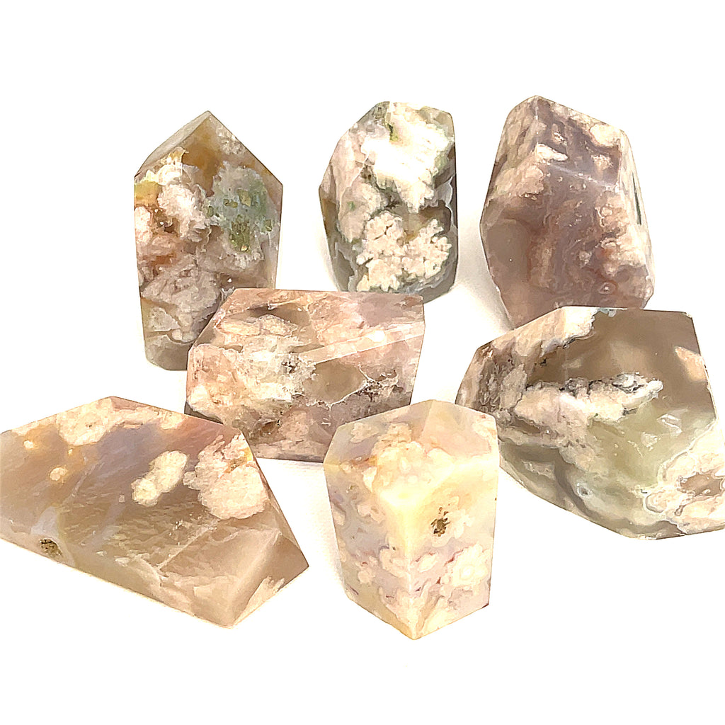 A collection of free-form Flower Agate gemstones with varying shades of brown, green, and white patterns, and on a white background, front overview.