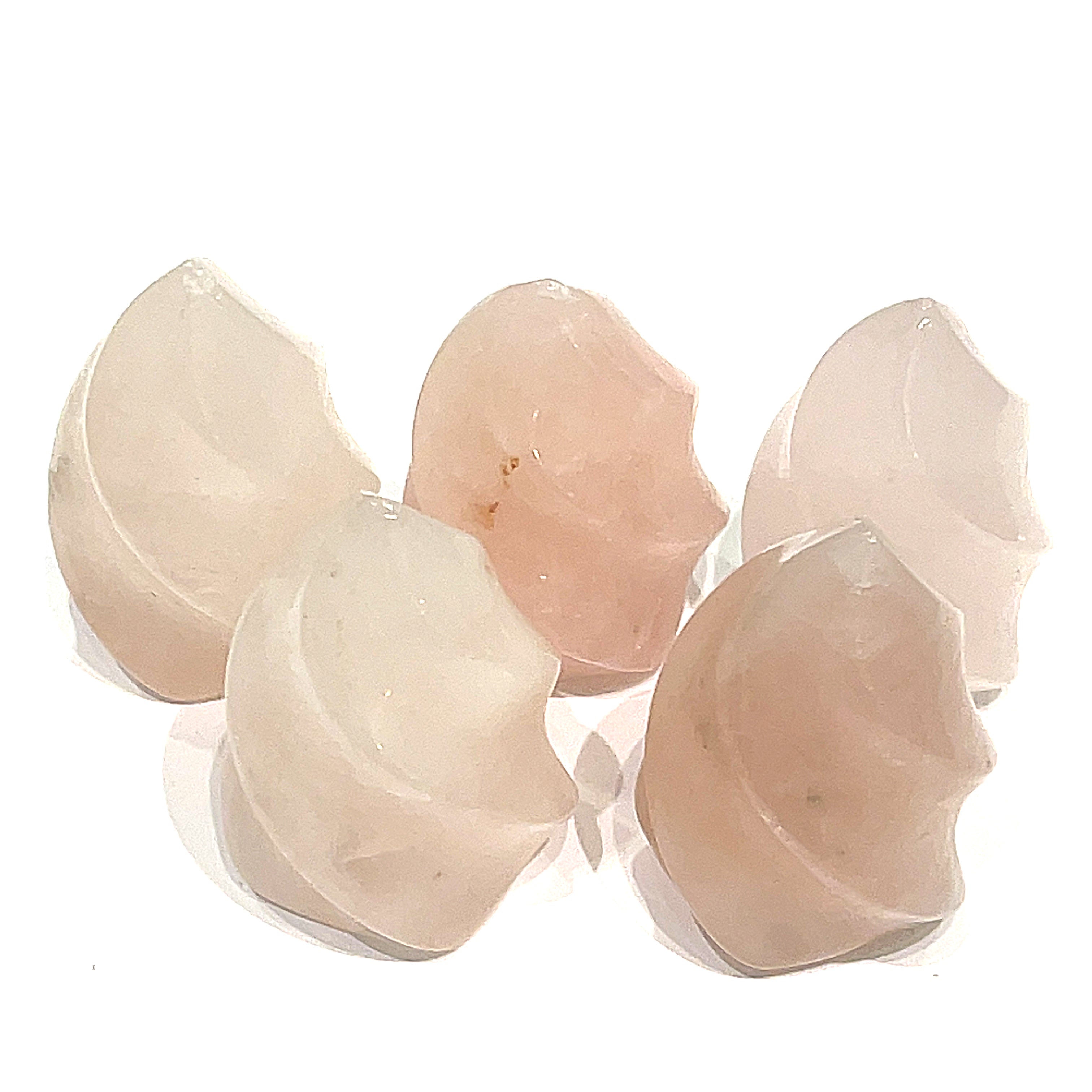 A collection of mini Rose Quartz gemstone flames displayed on a white surface, front overview. 