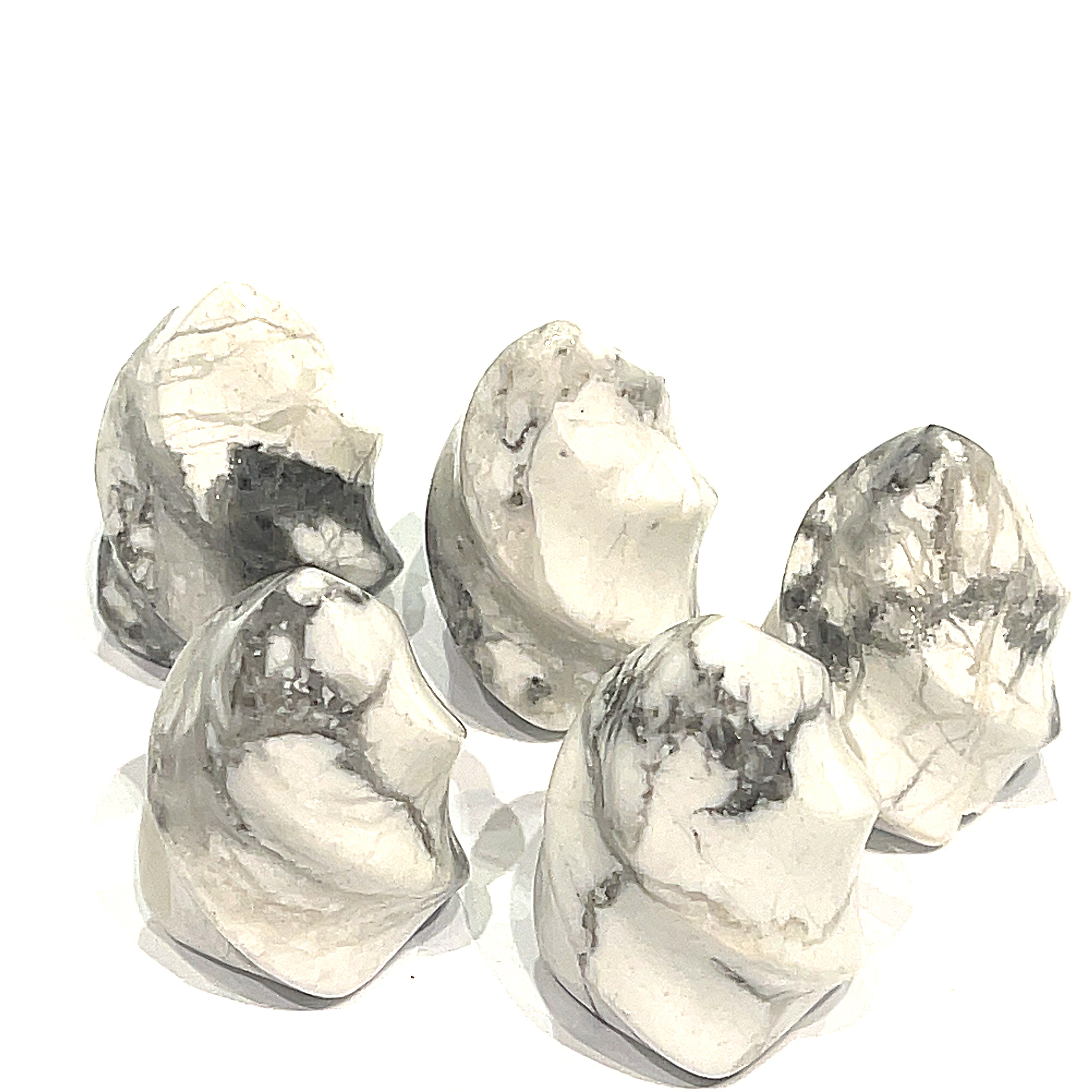 A collection of mini howlite gemstone flames displayed on a white surface, front overview. 