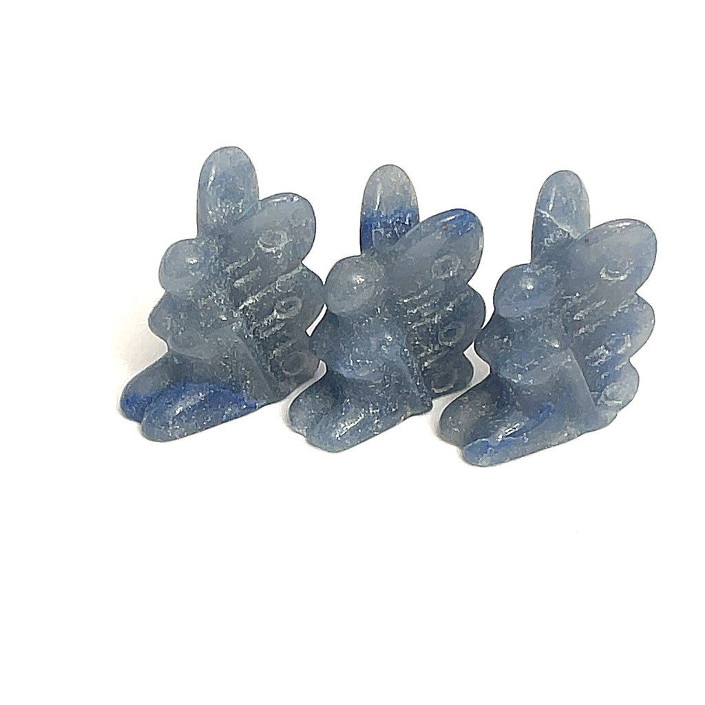 A collection of miniature gemstone carvings in, each resembling a fairy sitting with their hands on their lap, blue Aventruine displayed on a white background, front view. 