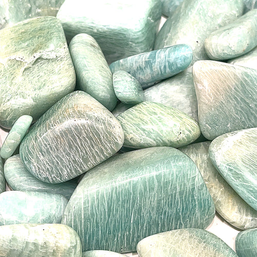 A collection of multiple sizes of Amazonite gemstone tumbles, front close up overview.  
