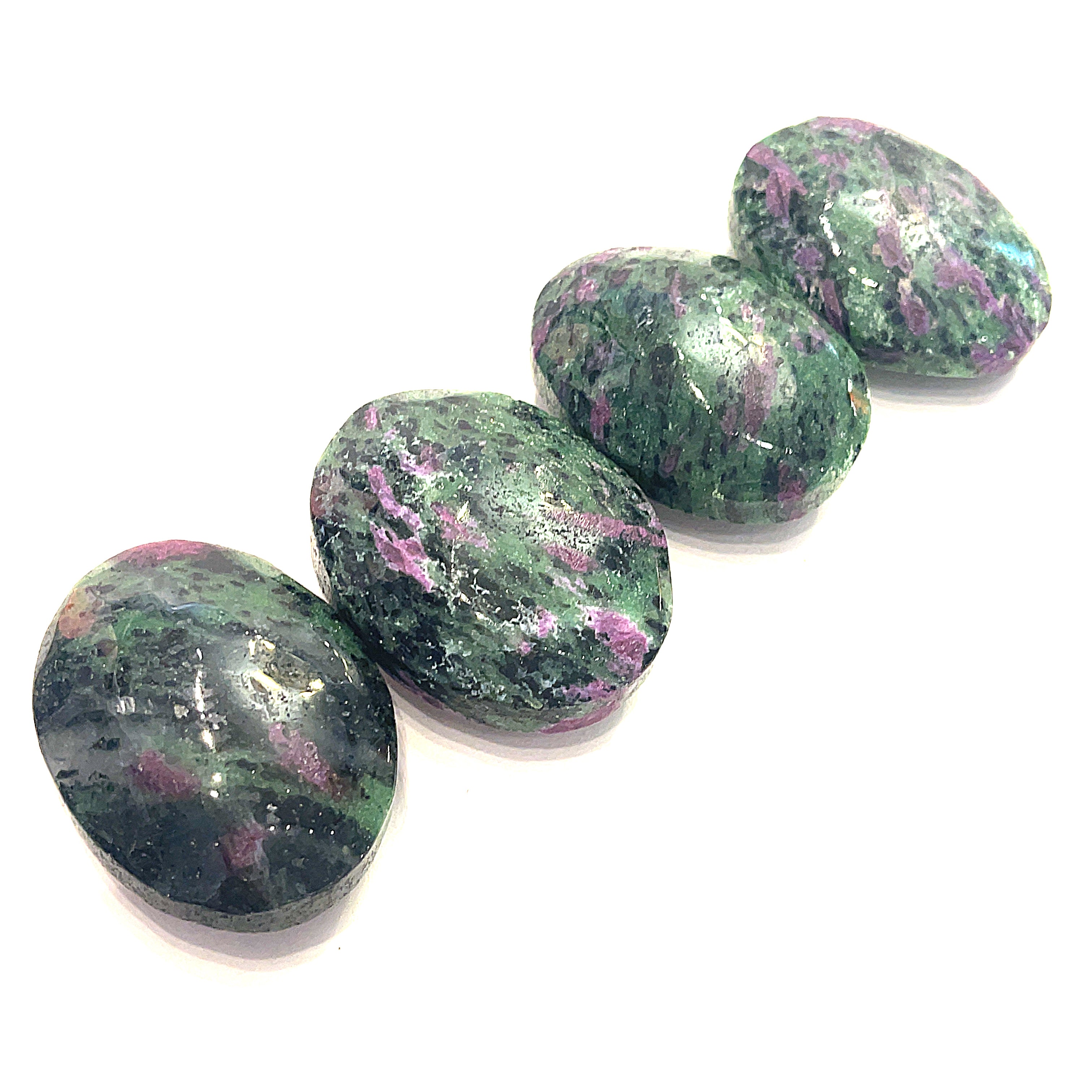 A collection of polished Ruby in Zoisite gemstone palm stones displayed on a white background in a line front overview.