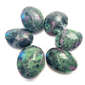 A collection of polished Ruby in Zoisite gemstone palm stones displayed on a white surface front overview.