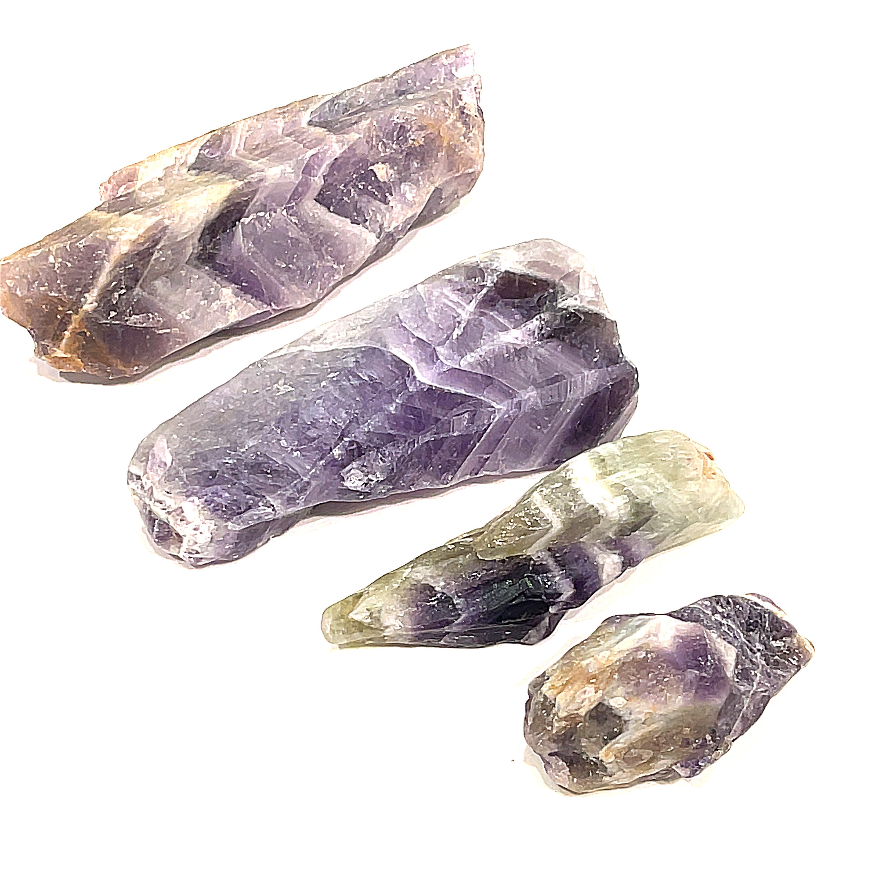 A collection of raw Amethyst or Prasiolite gemstones on a white background, front overview.