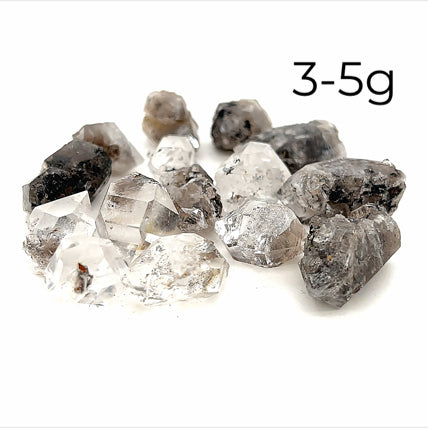 A collection of raw Herkimer diamond gemstones (3-5g) displayed on a white background, front overview. 