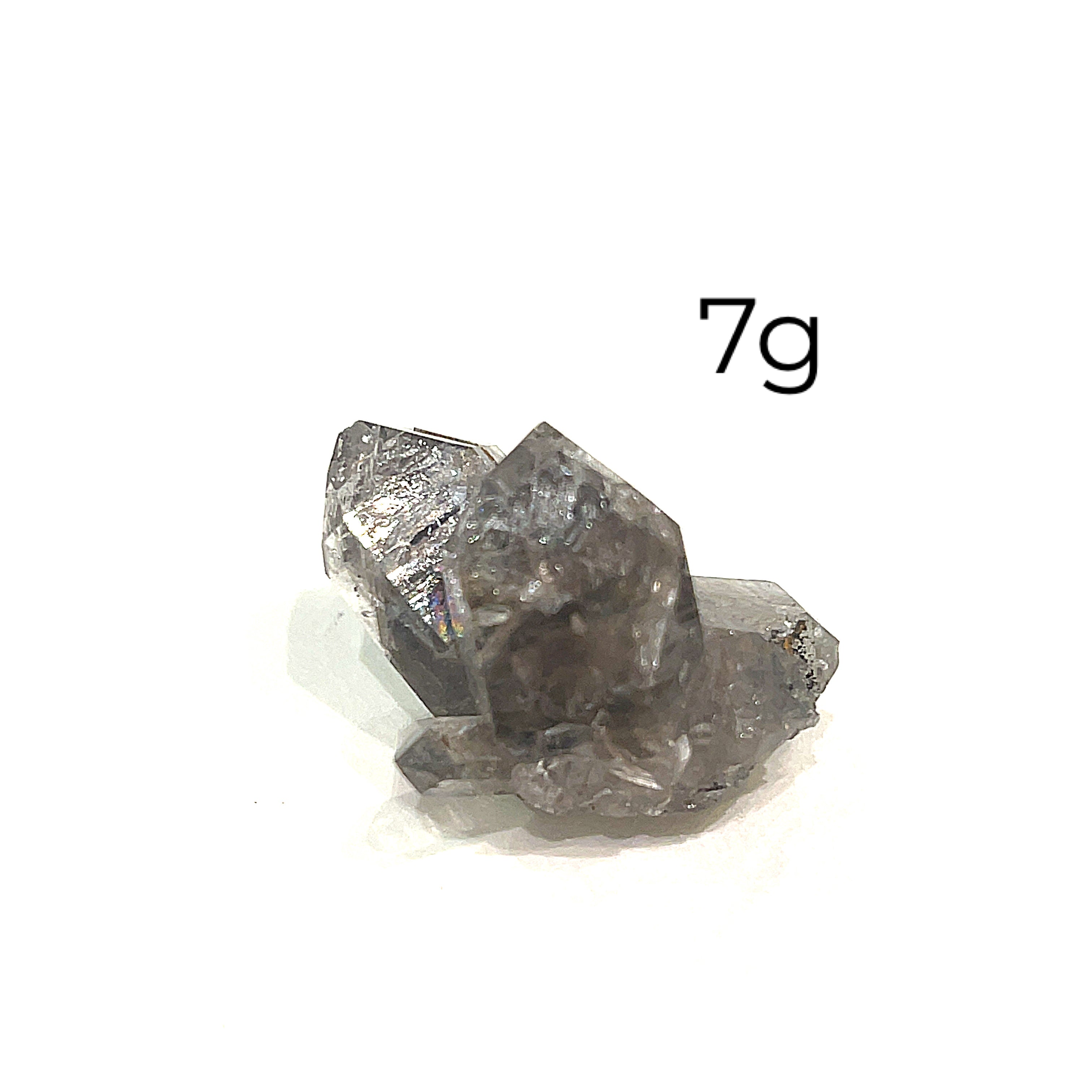 A collection of raw Herkimer diamond gemstones (7g) displayed on a white background, front, close up overview. 