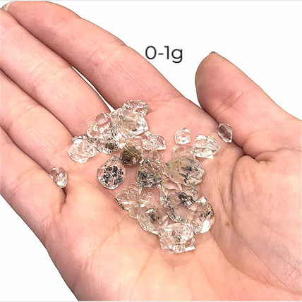 A collection of raw Herkimer diamond gemstones displayed on a model's palm-sized (0-1g) white background, front view. 