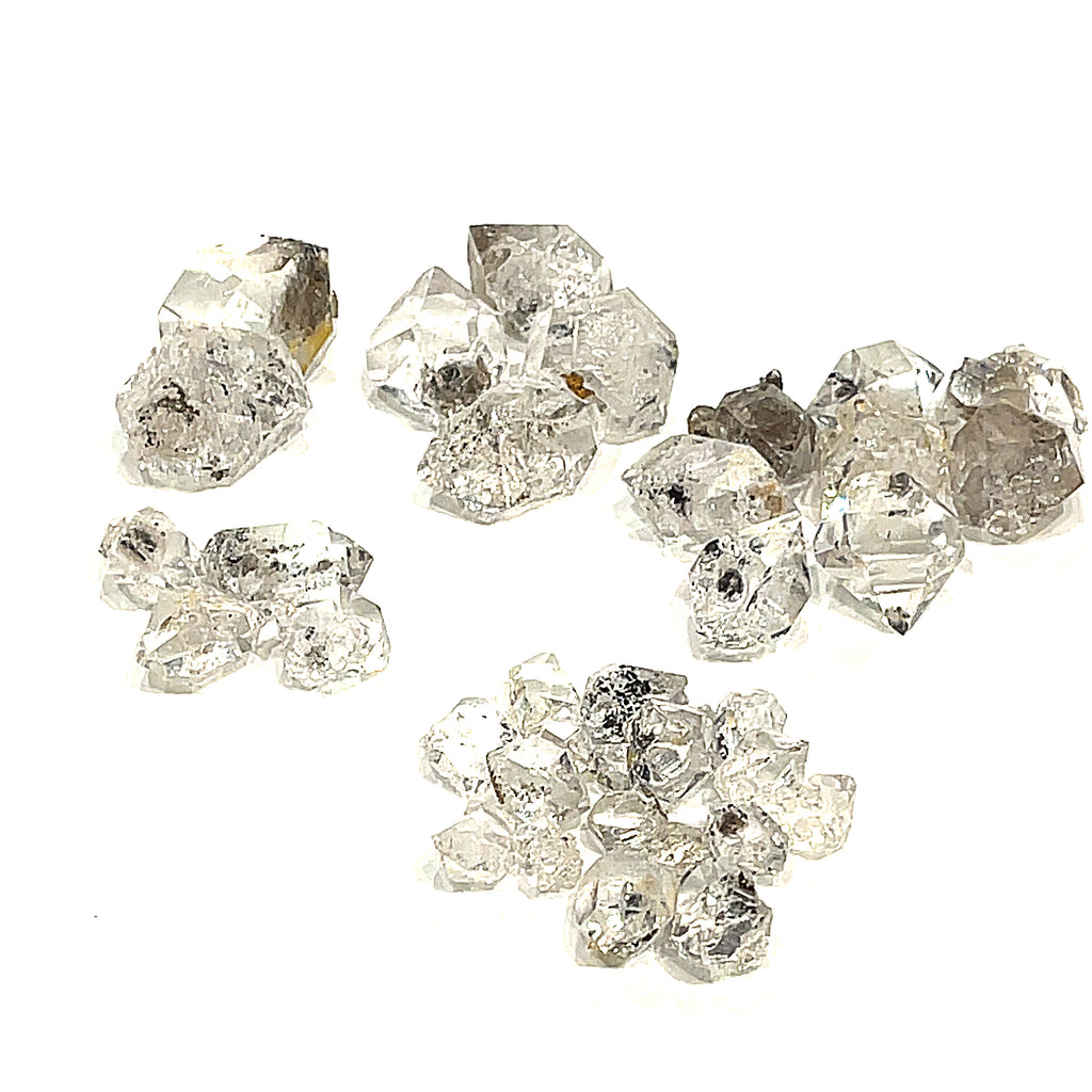 A collection of raw Herkimer diamond gemstones of different sizes displayed on a white background, front overview. 