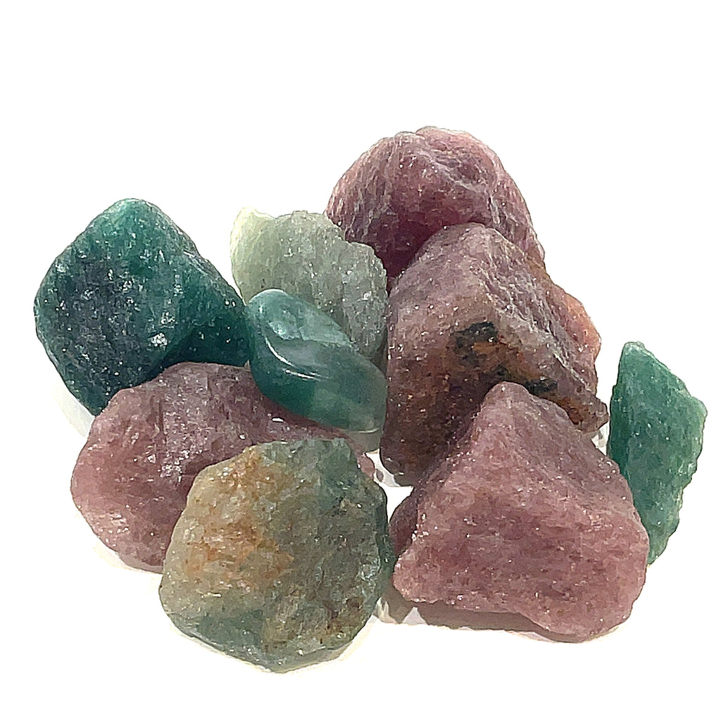 A collection of raw cherry and green tanzurine gemstones against a white background, front overview. 