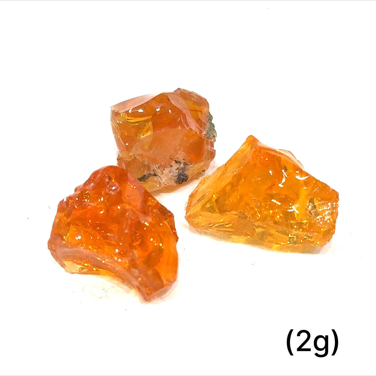 A collection of raw fire Ethiopian opal gemstones with varying colors, displayed on a white background, 2g.