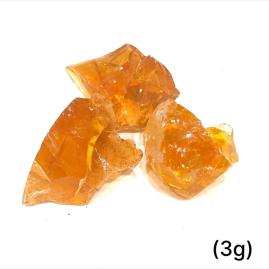 A collection of raw fire Ethiopian opal gemstones with varying colors, displayed on a white background, 3g.