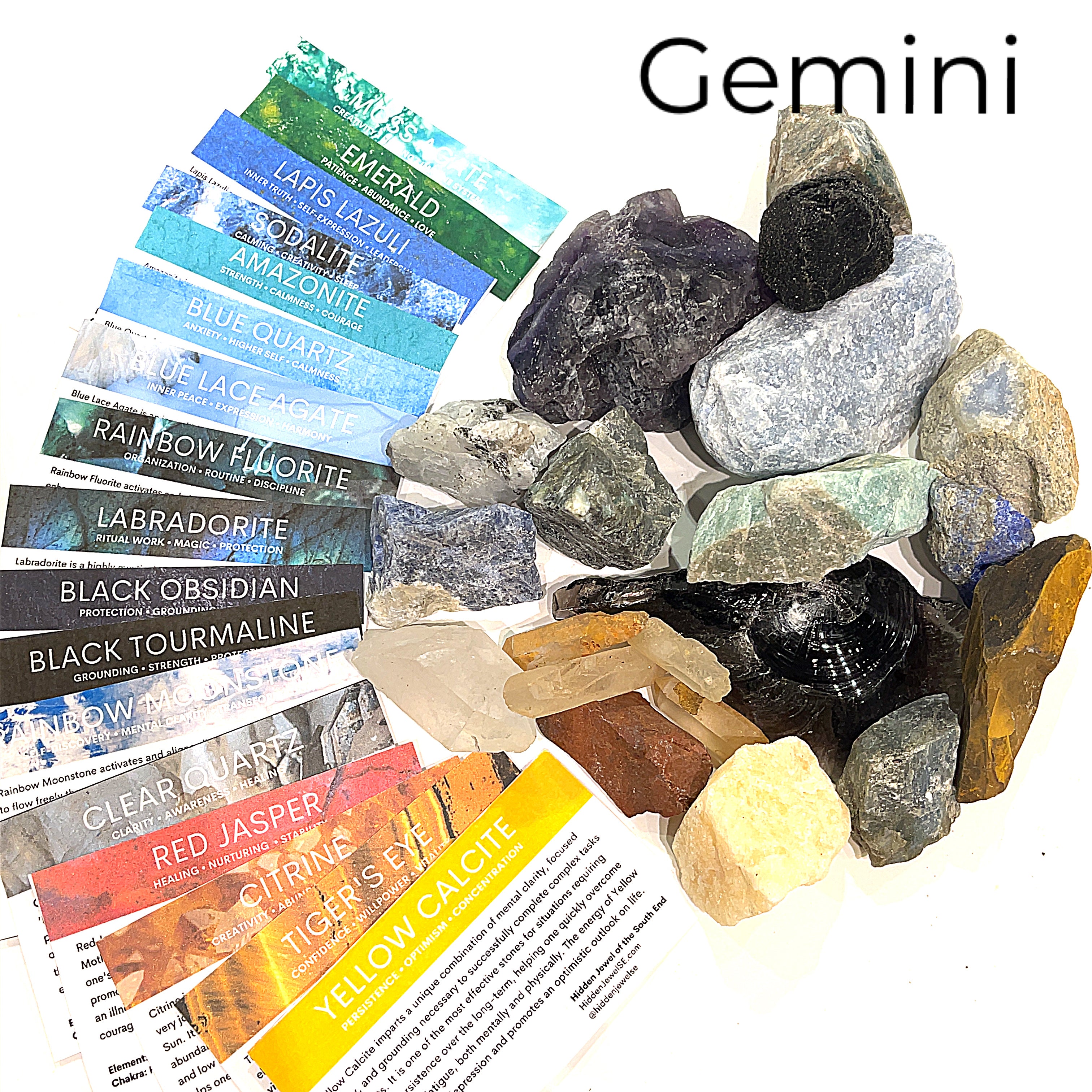 A collection of raw gemstones spread out, each labeled with its type, such as Aquamarine, Amethyst, and others. The label at the top says 'Gemini'.