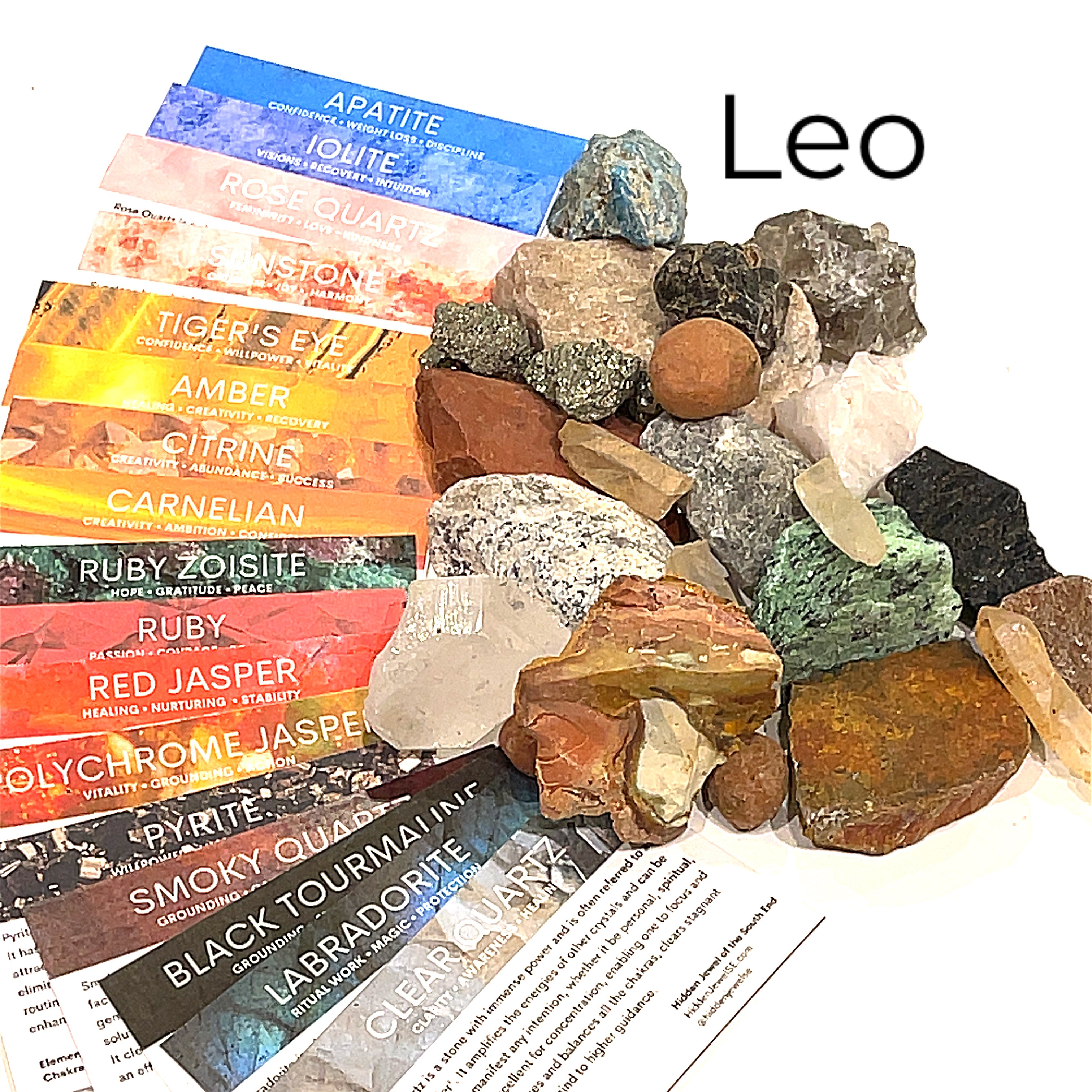 A collection of raw gemstones spread out, each labeled with its type, such as Aquamarine, Amethyst, and others. The label at the top says 'Leo'.