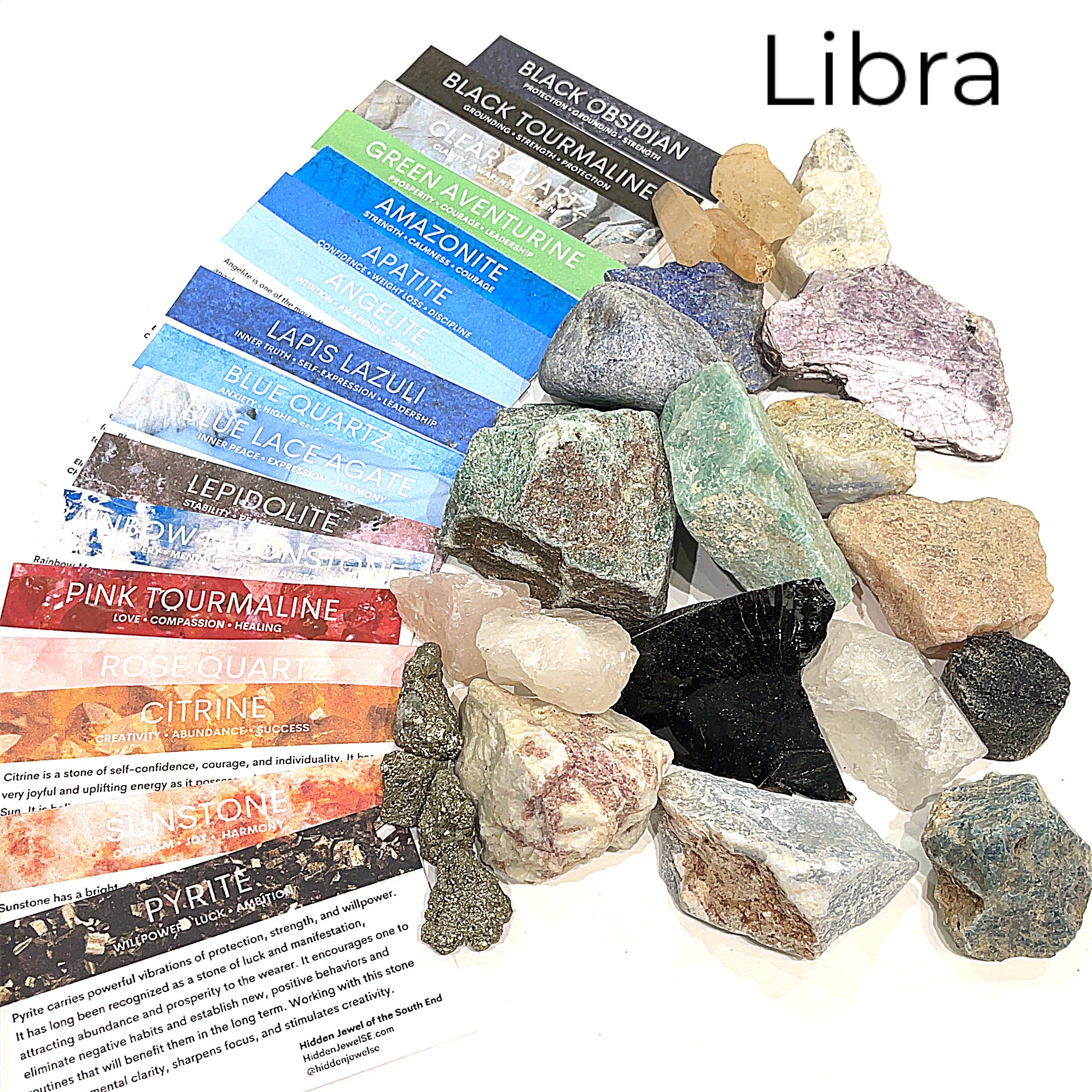 A collection of raw gemstones spread out, each labeled with its type, such as Aquamarine, Amethyst, and others. The label at the top says 'Libra'.