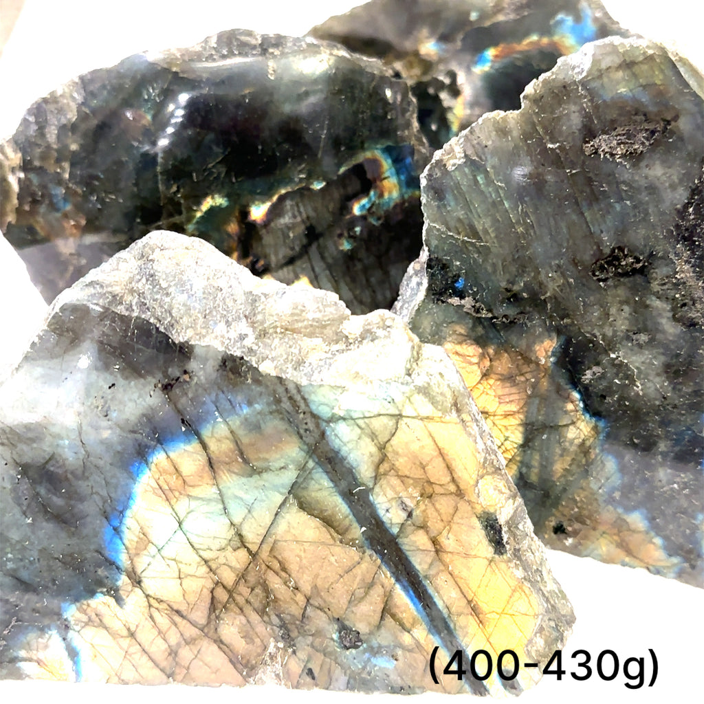 A collection of raw slab gemstones with a metallic sheen, predominantly gray in color, with hints of blue and other metallic colors reflecting off their surfaces on a white background, sizes (400-430g) front view