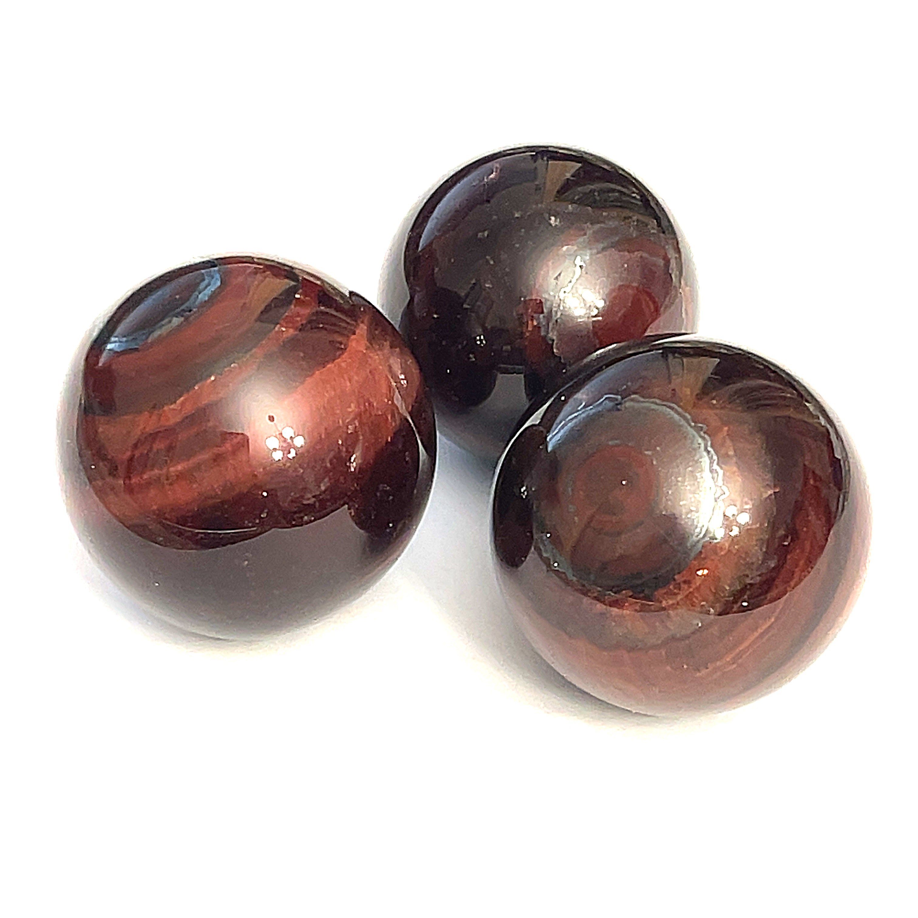 A collection of red tiger eye gemstone spheres, displayed on a white background in a triangular, front view.