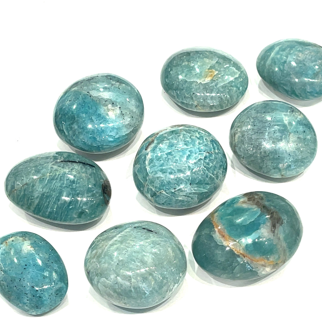 A collection of round Amazonite palm stones with a smooth, polished surface showcasing various shades of blue and green, on a white background. 