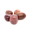 A collection of round Muscovite tumbled gemstones with a smooth, polished surface in shades of red and brown on a white background, front overview.