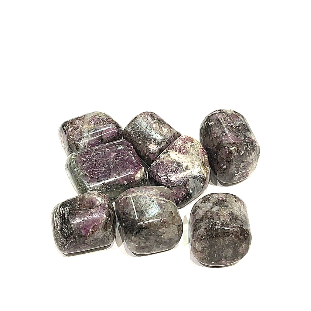 A collection of round tumbled Eudialyte gemstones with a purple and gray color palette on a white background, front overview.