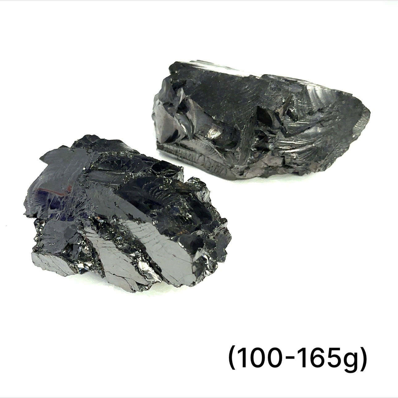 A collection of small raw Elite Shungite gemstone chunks (100-165g) on a white background, front overview. 