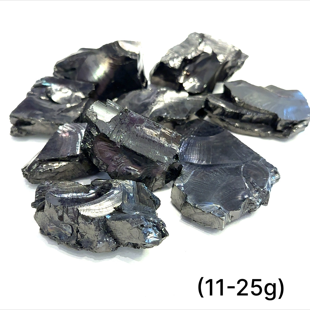 A collection of small raw Elite Shungite gemstone chunks (11-25g) on a white background, front overview. 