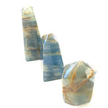 A collection of small sizes of  blue onyx gemstone towers displayed in a group on a white background, front overview.