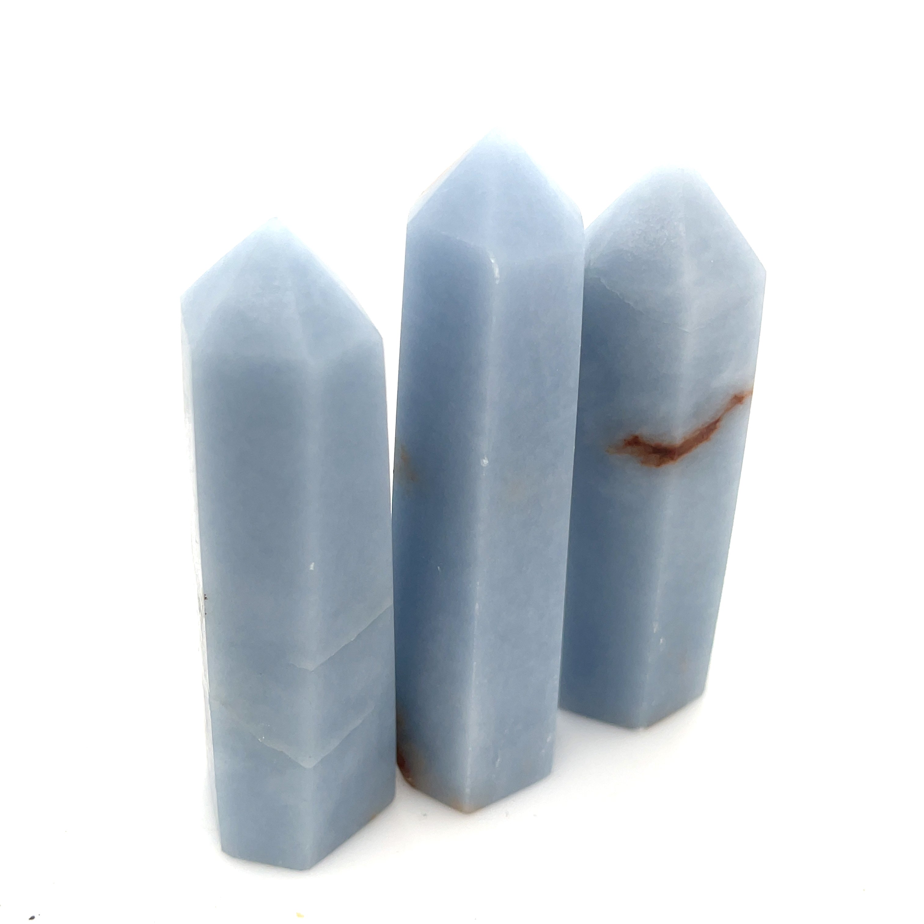 A collection of three Angelite gemstone towers displayed together on a white background front, center, close up  overview. 