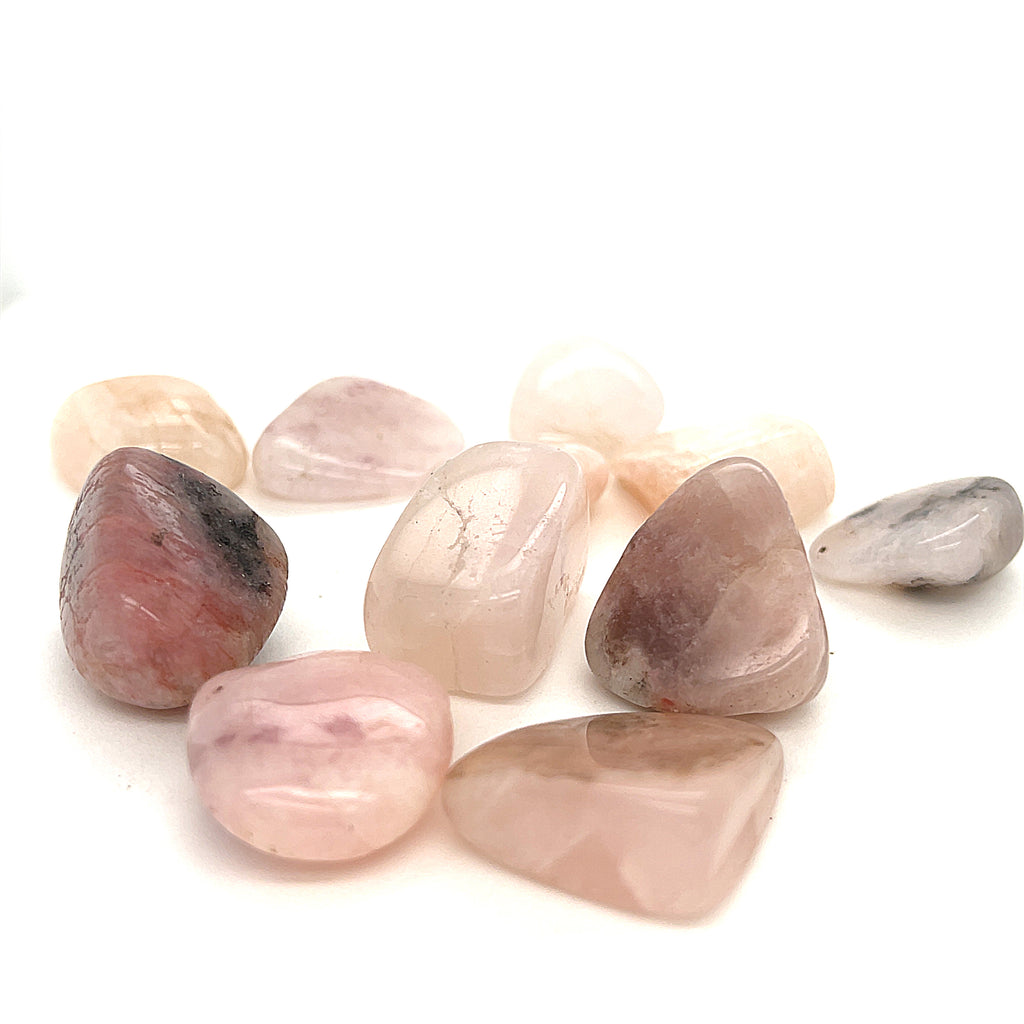 A collection of tumbled Petalite gemstones with a pink hue, displayed   on a white background, front overview.