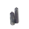 A collection of two Iolite gemstone towers displayed in a row, showing variations in color from light to deep blue with a purplish tint on a white background, front view. 