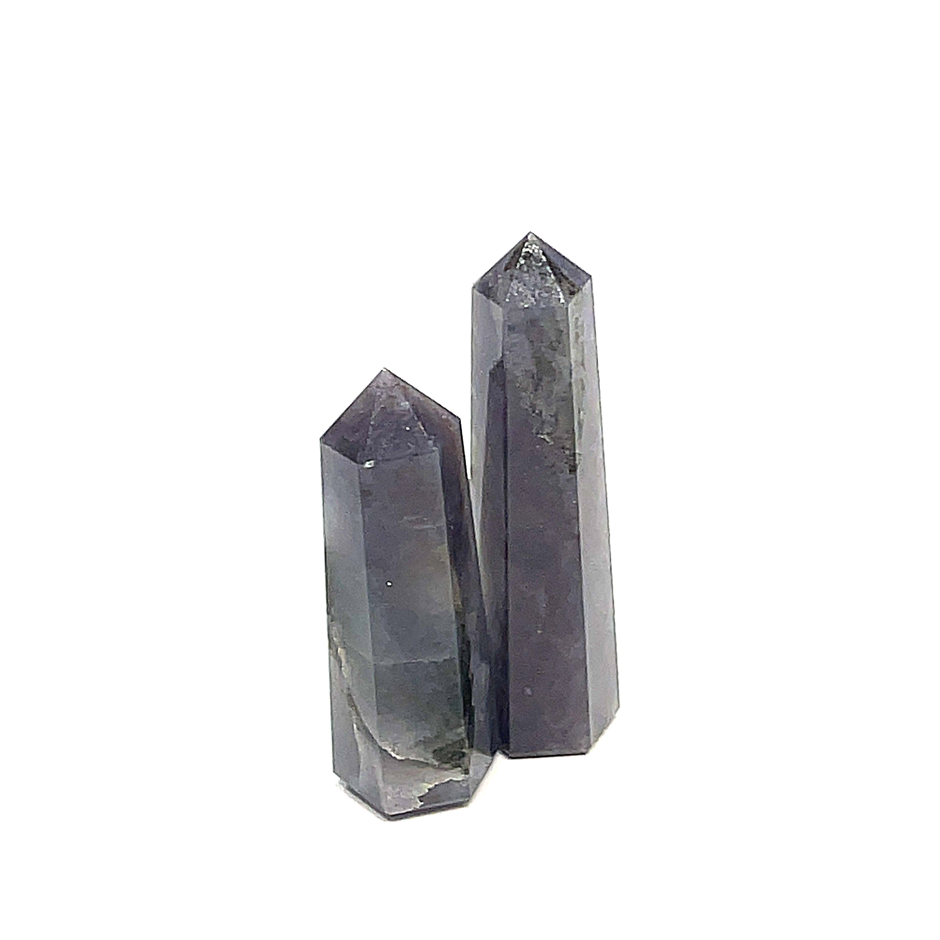 A collection of two Iolite gemstone towers displayed in a row, showing variations in color from light to deep blue with a purplish tint on a white background, front view. 